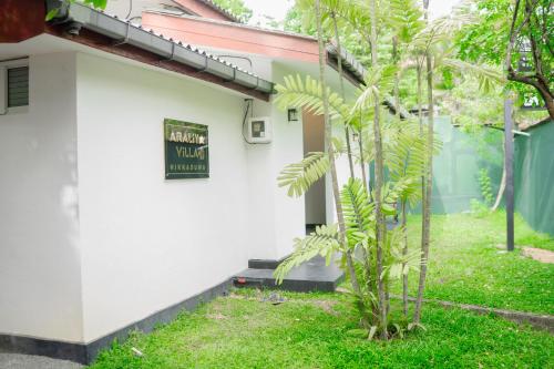 a white building with a sign on the side of it at Araliya Villa Hikkaduwa in Hikkaduwa