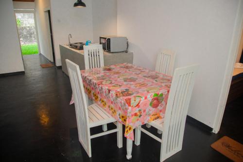 a table and chairs with a table cloth on it at Araliya Villa Hikkaduwa in Hikkaduwa