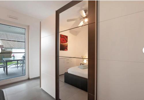 a mirror in a room with a bed and a table at großzügige Unterkunft mit Terrasse in Oberbrechen