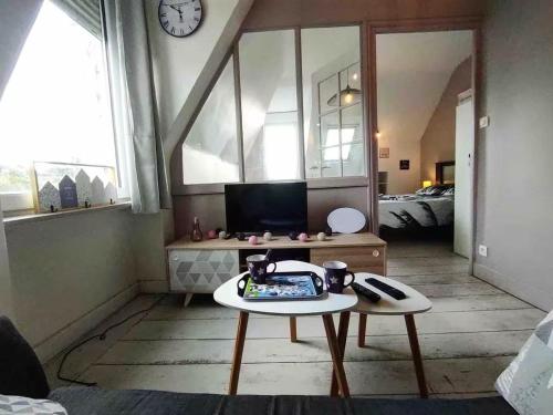 - un salon avec une table et une horloge murale dans l'établissement Ker Amel - Vue mer et parking, à Binic