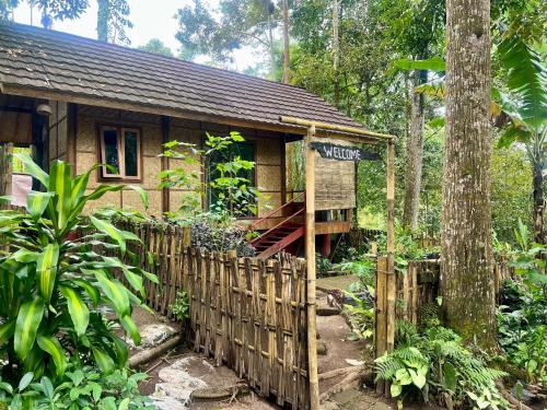 a small house in the woods with a fence at Joben Ecolodge in Tetebatu