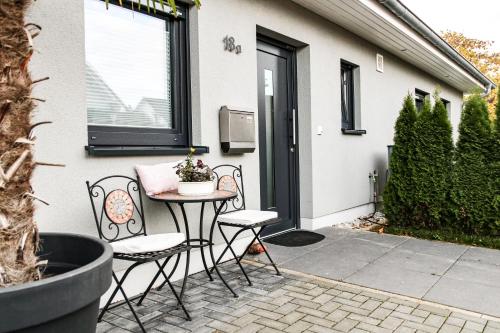 a patio with two chairs and a table and a window at großzügige Unterkunft mit Terrasse in Oberbrechen