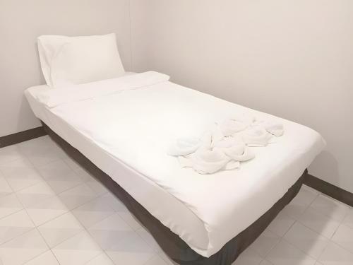 a bed with white sheets and white dishes on it at Mitr INN Phuket Oldtown - มิตร ภูเก็ต in Phuket Town