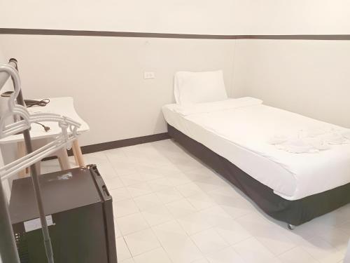 a small bed in a room with a suitcase at Mitr INN Phuket Oldtown - มิตร ภูเก็ต in Phuket Town