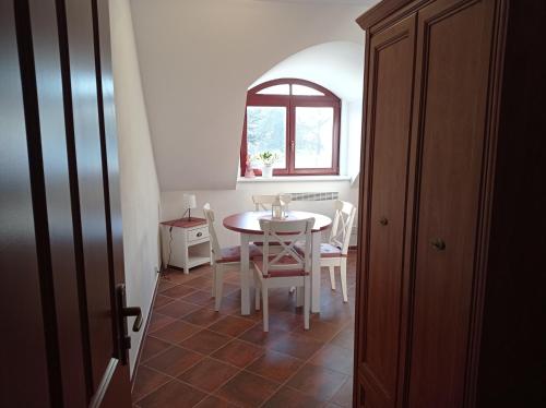 a dining room with a table and chairs and a window at Apartmány U Orlického jezera - Kamenice in Klučenice