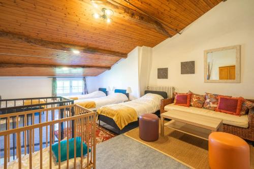 a living room with two beds and a balcony at Les gîtes du logis in Saint-Romain-de-Benet