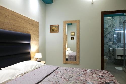 a bedroom with a large bed and a mirror at Casa Michelangelo in Porto SantʼElpidio