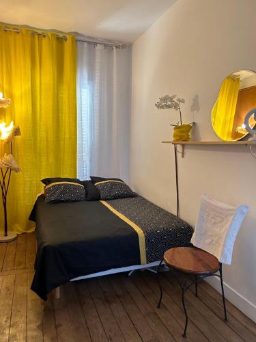 - une chambre avec un lit et un rideau jaune dans l'établissement StPaul2 Appt Rive Droite centre Marais, à Paris