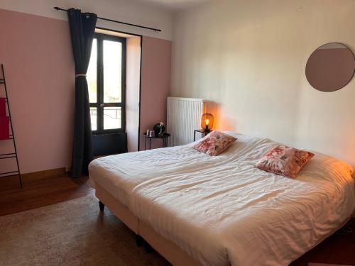 une chambre avec un grand lit blanc avec deux oreillers dans l'établissement Le Moulin en Route kamer rose en grijs, badkamer en suite, à Blèves