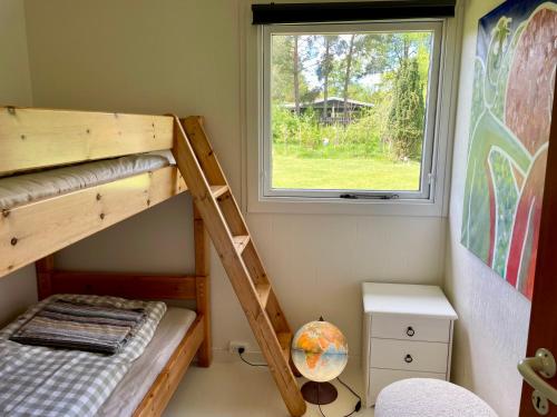 a bedroom with two bunk beds and a window at Cozy summer cottage with orangery close to Heatherhill and Beach in Vejby