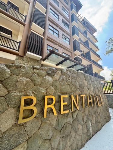 a sign on a stone wall in front of a building at Cordillera Breeze Suites Baguio Transient at Brenthill Condo in Baguio