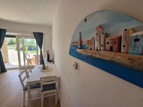 a room with a table and a painting on the wall at Apartments Leticia in Baška