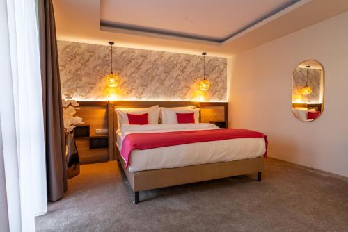 a bedroom with a large bed with red and white pillows at PENSIUNEA GAMBRINUS **** in Miercurea-Ciuc