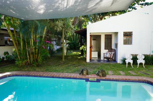 a house with a swimming pool in front of a house at Moonstone Lodge in Ponta do Ouro