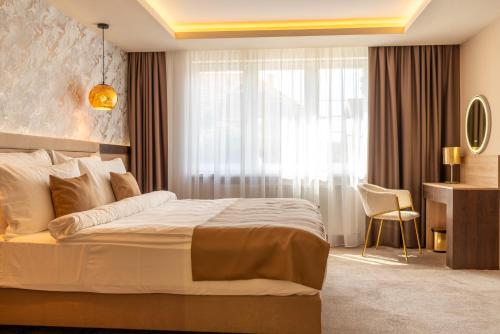 a hotel room with a bed and a window at PENSIUNEA GAMBRINUS **** in Miercurea-Ciuc