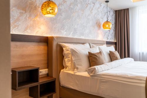 a bedroom with a bed with two lights on it at PENSIUNEA GAMBRINUS **** in Miercurea-Ciuc