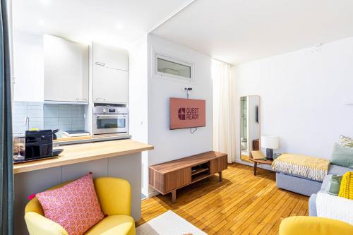 un petit salon avec un canapé et une cuisine dans l'établissement GuestReady - Peaceful Retreat in Batignolles, à Paris