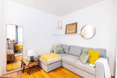 un salon avec un canapé et un miroir dans l'établissement GuestReady - Peaceful Retreat in Batignolles, à Paris