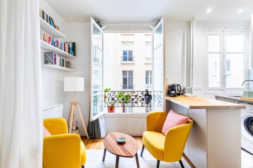 un salon avec des chaises jaunes et une table dans l'établissement GuestReady - Peaceful Retreat in Batignolles, à Paris