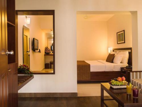 a hotel room with a bed and a mirror at Abad Copper Castle Resort in Munnar