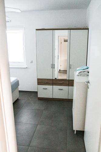a kitchen with white cabinets and a tile floor at Ruhige Wohnung mit Terrasse in Oberbrechen