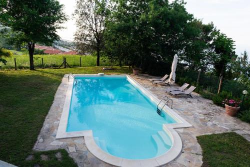 a swimming pool in a yard with two chairs at Villa Calibani in Trebbiantico