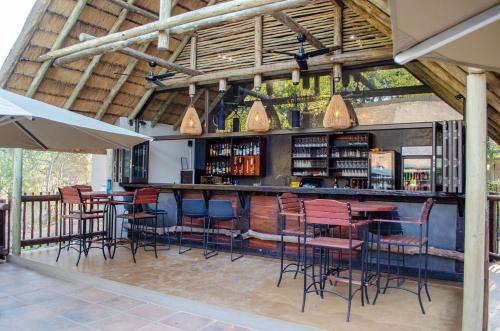 an outdoor bar with chairs and tables and lights at Umkumbe Bush Lodge - Luxury Tented Camp in Sabi Sand Game Reserve
