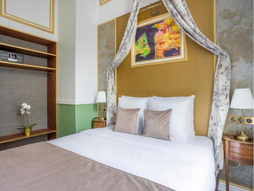 - une chambre avec un lit à baldaquin et des oreillers blancs dans l'établissement Merveil - Luxury Suite - Notre-Dame - Saint Louis, à Paris