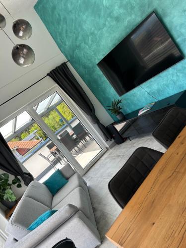 a living room with a couch and a flat screen tv at LUX PENTHOUSE Klopeiner See Apartment Ferienwohnung FeWo in Sankt Kanzian