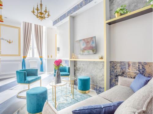 un salon avec des chaises bleues et un canapé dans l'établissement Merveil - Luxury Suite - Notre-Dame - Saint Louis, à Paris