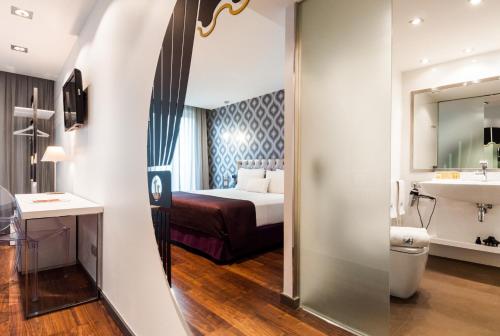 Habitación de hotel con cama y baño en Ikonik Ramblas en Barcelona