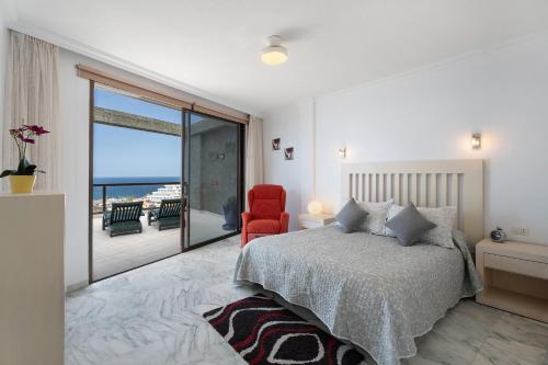 a bedroom with a bed and a view of the ocean at Al Mar Los Gigantes in Puerto de Santiago