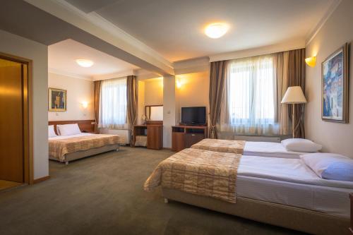 a hotel room with two beds and a television at Apollonia Hotel Gevgelija in Gevgelija