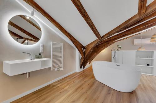 baño con bañera blanca grande y espejo en Le Gambetta - Élégance et Confort - Vue sur la Place Stanislas, en Nancy
