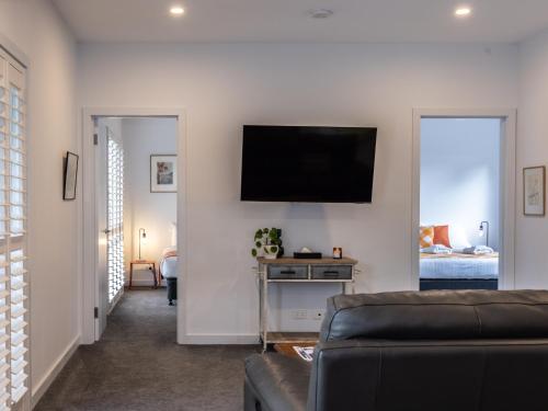a living room with a couch and a flat screen tv at The Dickins in Woodend