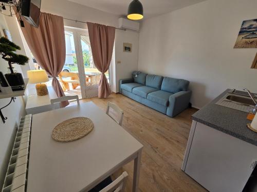 a living room with a table and a blue couch at Apartments Leticia in Baška