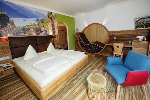 a bedroom with a bed and a desk and a chair at Hotel Lindenhof in Kellberg