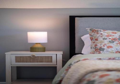 a bedroom with a bed and a lamp on a night stand at Hot Tub N64 Mins to Downtown Sleeps 8 in Cleveland