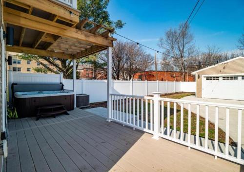a deck with a hot tub and a wooden pergola at Hot Tub N64 Mins to Downtown Sleeps 8 in Cleveland