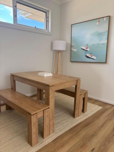 a wooden table and bench in a room with a tv at Seaside Daisy 3 Bedrooms 6 Beds in Goolwa