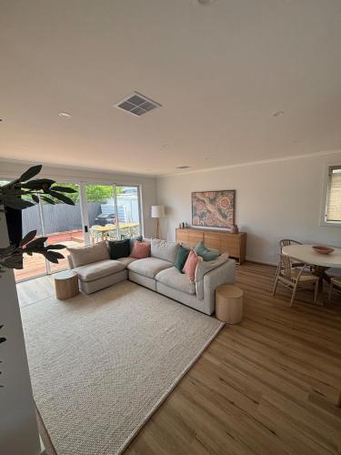 a living room with a couch and a table at Seaside Daisy 3 Bedrooms 6 Beds in Goolwa
