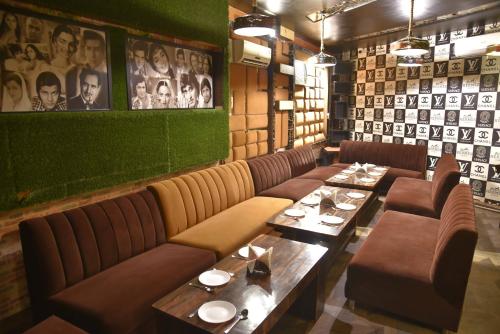 a restaurant with couches and tables and photos on the wall at Sky Star Hotel in Amritsar