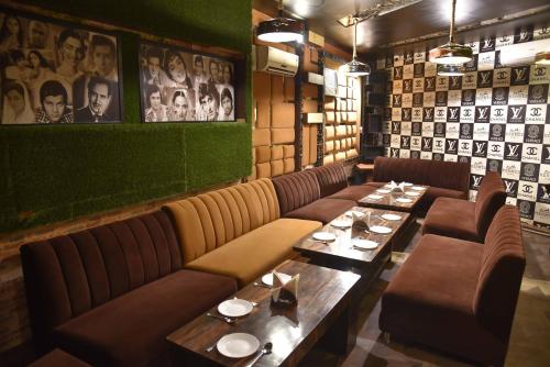 a restaurant with couches and tables and photos on the wall at Sky Star Hotel in Amritsar