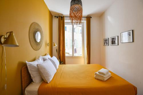 une chambre avec un lit avec des oreillers blancs et une fenêtre dans l'établissement Chez Pagnol - Appart 1 ch - St-Charles, à Marseille