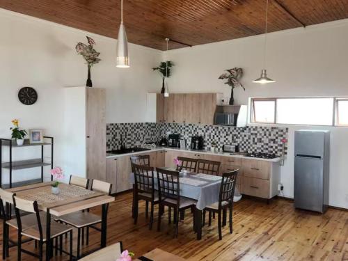 a kitchen with a table and chairs and a refrigerator at Seaview Sunsets in Gqeberha