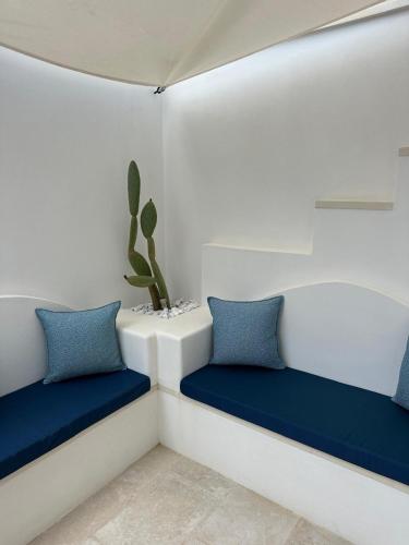 a room with two blue cushions and a cactus at Pascaraymondo Suite Palace in Gallipoli
