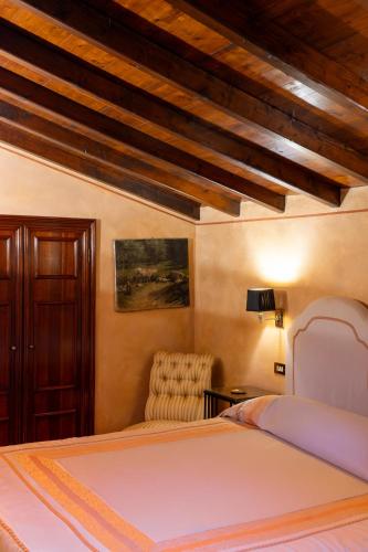 a bedroom with a bed and a chair at Locanda San Vigilio in Garda