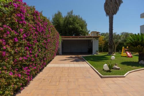 un seto con flores rosas en un patio en Villa Damare, en Taranto
