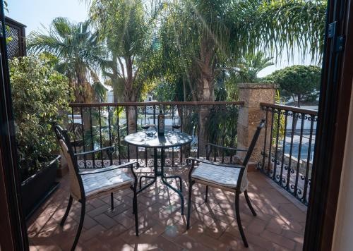 a patio with a table and chairs on a balcony at Hotel Azalea Playa in Chiclana de la Frontera