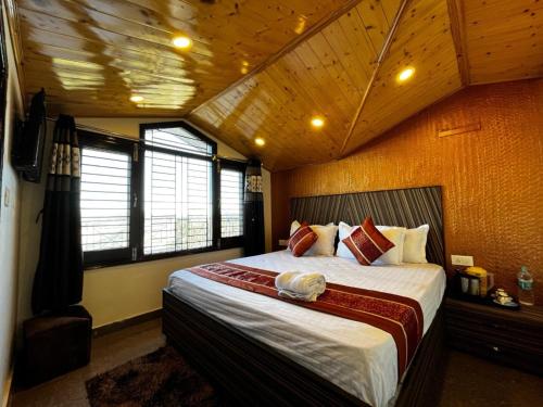 a bedroom with a large bed in a room with wooden ceilings at Shimla Mountain View Property Nirvana Rooms in Shimla